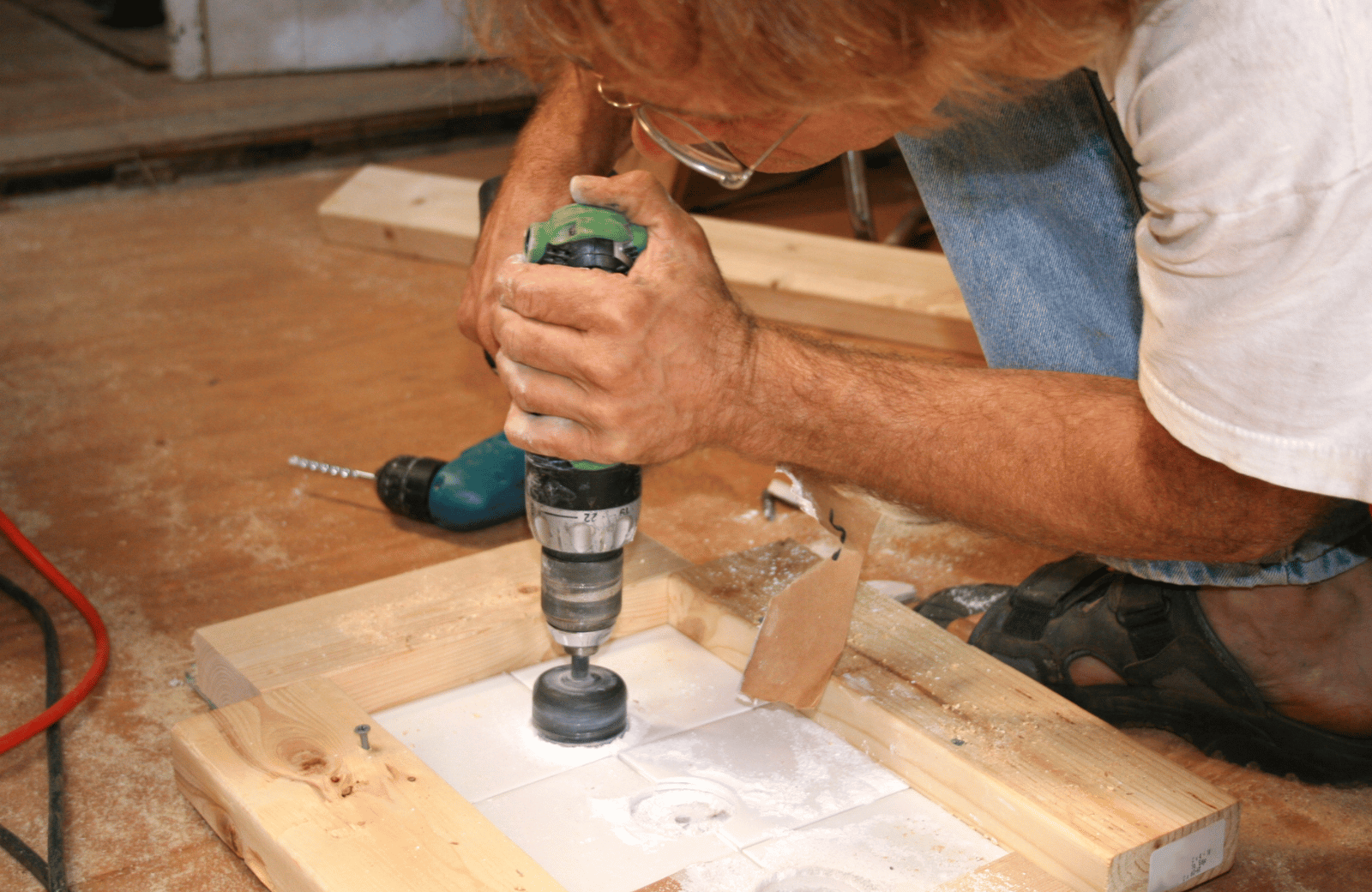 man drilling through tile