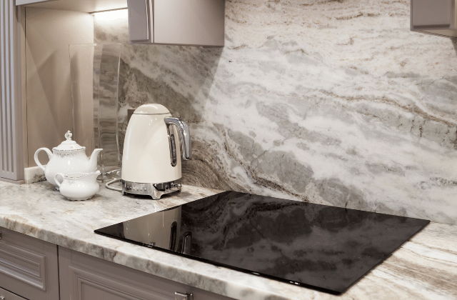 Kitchen with a grey and white marble backsplash and countertop
